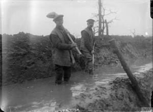 Two soldiers standing in a muddy trench